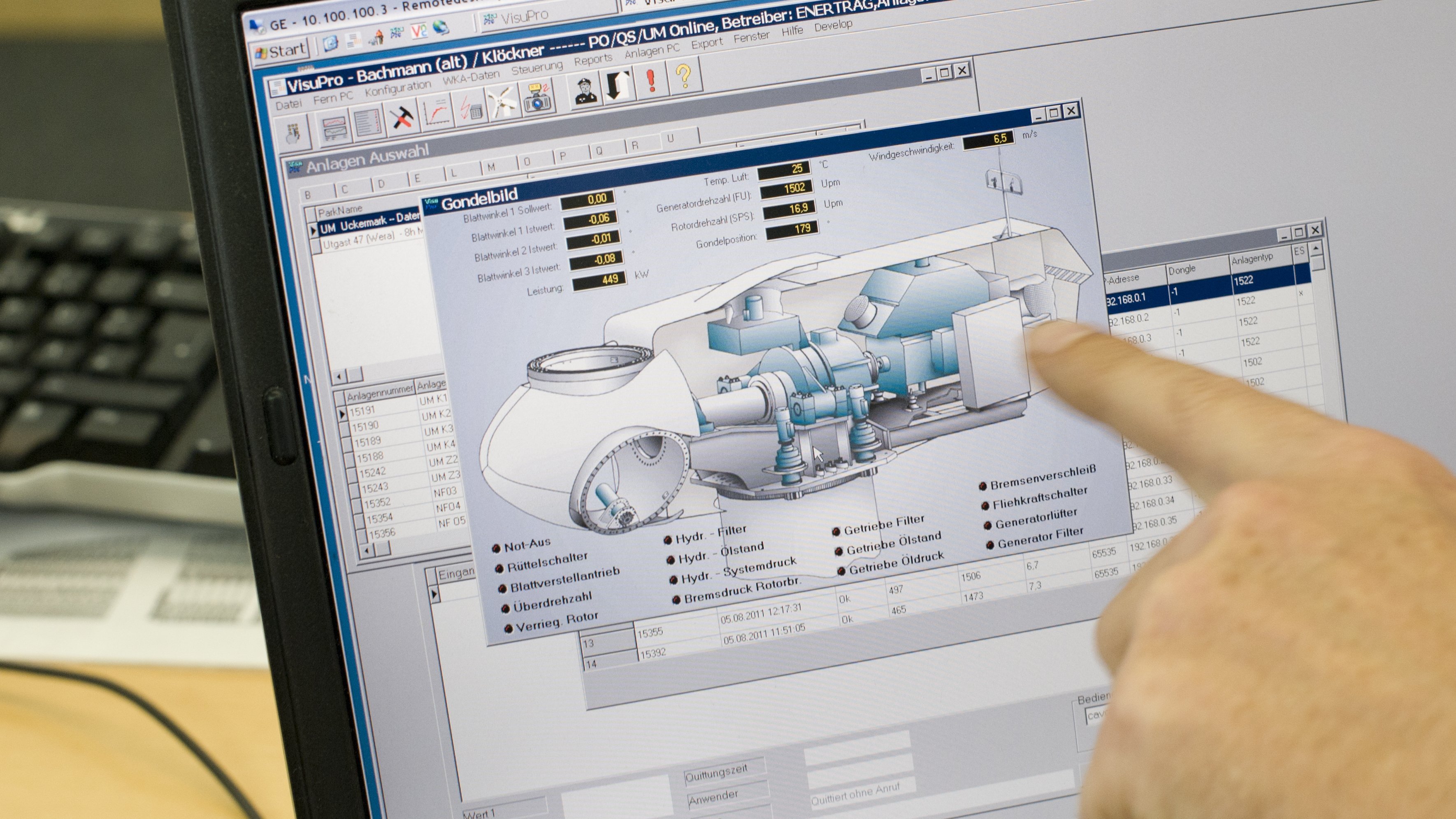 Eine Hand zeigt auf einen Bildschirm, auf dem Energieanlagen zu sehen sind