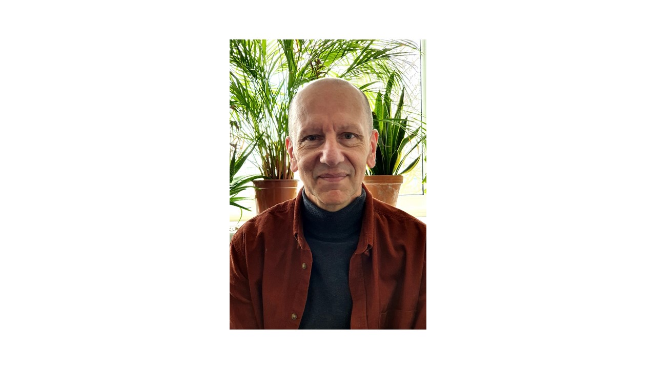 Foto von Thomas Lippert vor einer grünen Pflanze